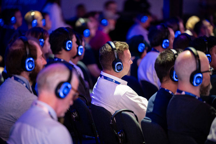 People in audience sitting and listening with headphones on