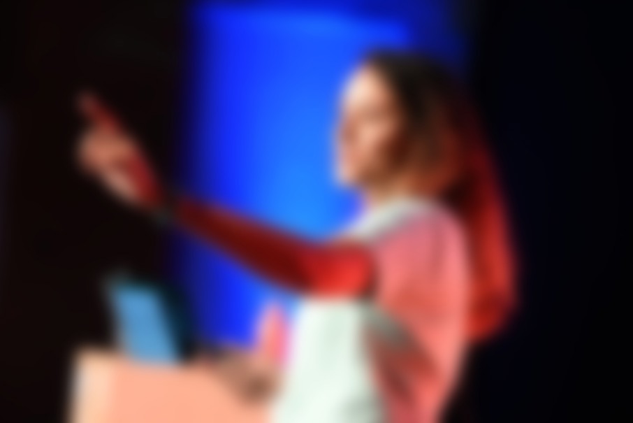 A developer speaking in front of a big screen showing code